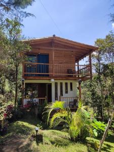 a large wooden house with a balcony on top at cabaña paniym in Rionegro