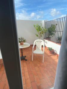a balcony with a white chair and a table at APARTAMENTO SAN JOSE in Palma del Río