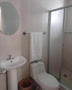a bathroom with a toilet and a sink and a mirror at HOTEL BLUE COSTA Panama in Panama City
