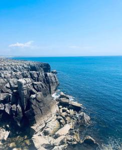 an aerial view of the ocean and a rocky shore at Peniche Hostel in Peniche