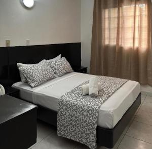 ein Schlafzimmer mit einem großen Bett mit Kissen in der Unterkunft HOTEL BLUE COSTA Panama in Panama-Stadt