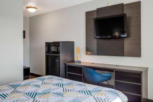 Habitación de hotel con cama, escritorio y TV. en Motel 6-Carson City, NV en Carson City