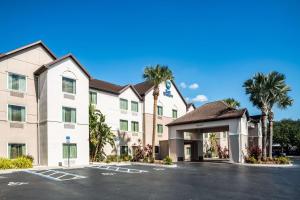 un hotel con palmeras en un aparcamiento en Best Western Auburndale Inn & Suites, en Auburndale