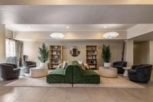 sala de estar con sofá verde y sillas en Best Western Auburndale Inn & Suites en Auburndale