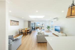 安娜湾Bel Air, 8A Ocean Ave - pet friendly, water views and air con的带桌子的客厅和餐厅