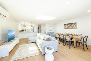 安娜湾Bel Air, 8A Ocean Ave - pet friendly, water views and air con的客厅以及带沙发和桌子的厨房。