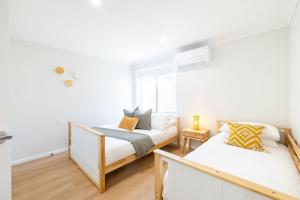 安娜湾Bel Air, 8A Ocean Ave - pet friendly, water views and air con的有两张床和一扇窗户的卧室