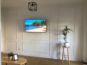 ein Wohnzimmer mit einem an der Wand hängenden TV in der Unterkunft Primera linea playa valdelagrana vistas al mar in El Puerto de Santa María