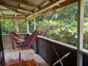 a hammock on the porch of a house at Riversideview House in Calibishie