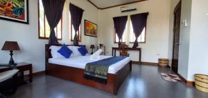 een slaapkamer met een bed met blauwe kussens bij Palmera Palma Top Floor in Moalboal