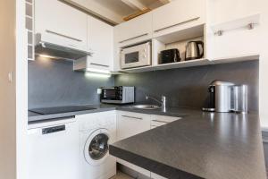 比亞里茨的住宿－Cosy duplex apartment with ocean view in Biarritz - Welkeys，厨房配有白色橱柜和洗衣机。