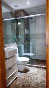 a bathroom with a toilet and a sink and a shower at Brasil flats Cullinan particular in Brasilia