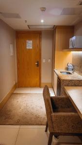 a room with a kitchen with a wooden door at Brasil flats Cullinan particular in Brasilia
