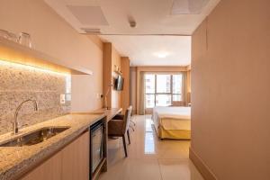 a bathroom with a sink and a bedroom with a bed at Brasil flats Cullinan particular in Brasilia