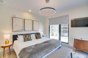 een slaapkamer met een bed en een groot raam bij Winter Park Condo with Hot Tub, Balcony and Shuttle! in Winter Park