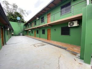 pusty dziedziniec budynku z zielonymi ścianami w obiekcie Apartamentos IVAGO w mieście Encarnación