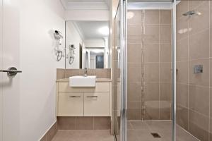 uma casa de banho com um chuveiro, um lavatório e um espelho. em Cozy Double Room in Panania Guesthouse em Panania