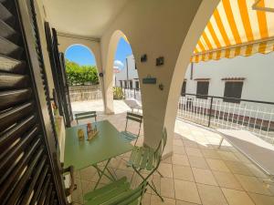 um pátio com uma mesa e cadeiras numa varanda em Casa La Perla - Alloggio con terrazza panoramica, piscina e free parking em Ceriale