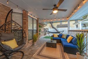 um alpendre com um sofá azul e uma ventoinha de tecto em Beautiful Texas Ranch House, Game Room & Minigolf em San Antonio