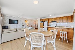 a kitchen and living room with a table and chairs at Grand Pacific 1 Unit 1 - Ground Floor in Narooma