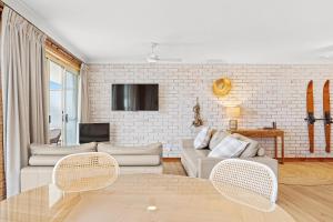 a living room with a couch and a table at Grand Pacific 1 Unit 1 - Ground Floor in Narooma