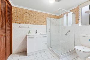 a bathroom with a glass shower and a toilet at Grand Pacific 1 Unit 1 - Ground Floor in Narooma +14 photos