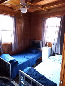 a bedroom with two beds and two windows at Mx2 Cottage in Calibishie