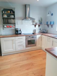 a kitchen with white cabinets and a wooden floor at Castlebar 3 bedroom house in Castlebar