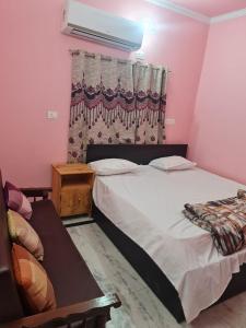 a bedroom with a large bed and a window at SPOT ON Aaditya Hotel in Patna