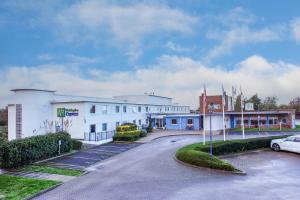 a building with a car parked in a parking lot at Holiday Inn Express Ramsgate – Minster by IHG in Minster