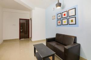 a living room with a leather chair and a table at OYO Flagship Saket Homes in Bhubaneshwar