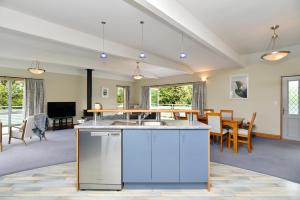a kitchen and living room with a table and chairs at Watson Street - Bookahome in Akaroa