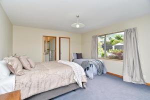 a bedroom with two beds and a window at Watson Street - Bookahome in Akaroa