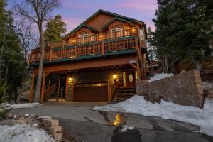 a large wooden house with a deck in the snow at 5 Star Family Cabinhot Tubpool Tableev Charger in Big Bear Lake
