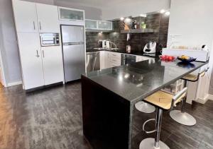 uma cozinha com um balcão preto e electrodomésticos brancos em Suite Coco CarIbe em Porlamar
