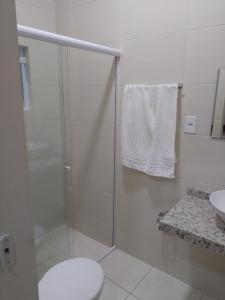 a bathroom with a shower with a toilet and a sink at Pousada Mundo Novo in Aparecida