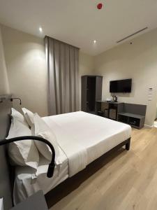 فندق هومي في المدينة المنورة: غرفة نوم بسرير ومكتب وتلفزيون