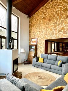 a living room with a couch and a stone wall at Villa Mirador in Manzanera