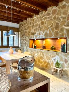 a dining room with a table and a stone wall at Villa Mirador in Manzanera