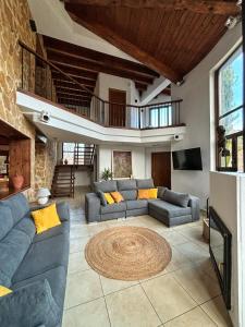 a living room with blue couches and a wooden ceiling at Villa Mirador in Manzanera