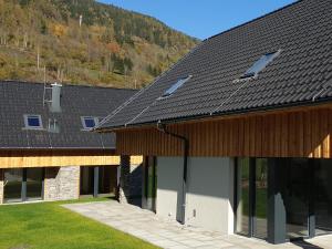 a building with a black roof with glass windows at Mountain Chalet Chapeau in Sankt Lorenzen ob Murau