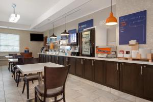 Holiday Inn Express Hotel & Suites Barrie, an IHG Hotel في باري: مطعم بطاولة وكراسي وكاونتر