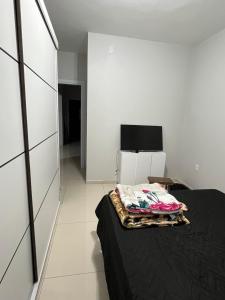 sypialnia z łóżkiem i telewizorem w obiekcie Casa com piscina em Imbé/Rs w mieście Imbé