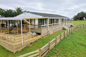 a wooden house with a fence around it at Apartment 3 in Auckland