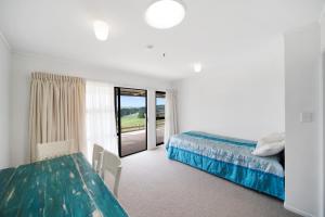 sypialnia z łóżkiem, stołem i oknem w obiekcie Apartment 3 w Auckland
