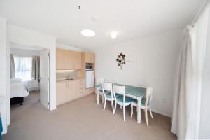 a kitchen and dining room with a table and chairs at Apartment 3 in Auckland