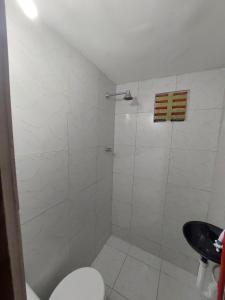 een badkamer met een douche, een toilet en een wastafel bij Duplex econômico vila ponta negra in Natal