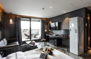 a living room with a white refrigerator in a room at Mari Hotel Terminal Branch in Jeonju