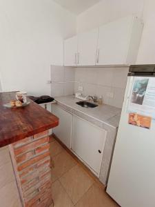 cocina con armarios blancos y nevera blanca en Monoambiente Carlos Paz en Villa Carlos Paz