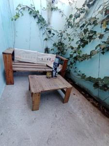 un banco sentado junto a una pared con una planta en Monoambiente Carlos Paz en Villa Carlos Paz